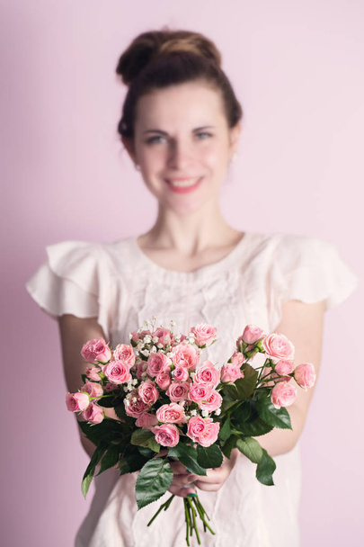 女性がバラの花束を保持しています。 - 写真・画像