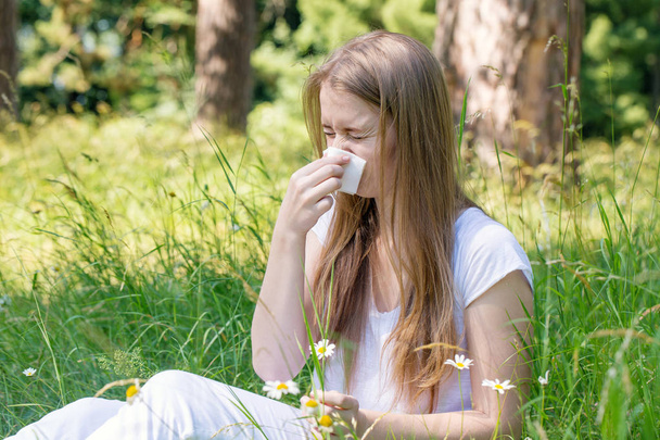 Donna nel prato starnutisce, il concetto di allergia
 - Foto, immagini