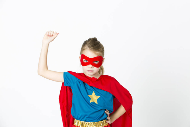pretty blonde super girl in costume with red mask and cape posing isolated on white background, superhero concept - Foto, immagini