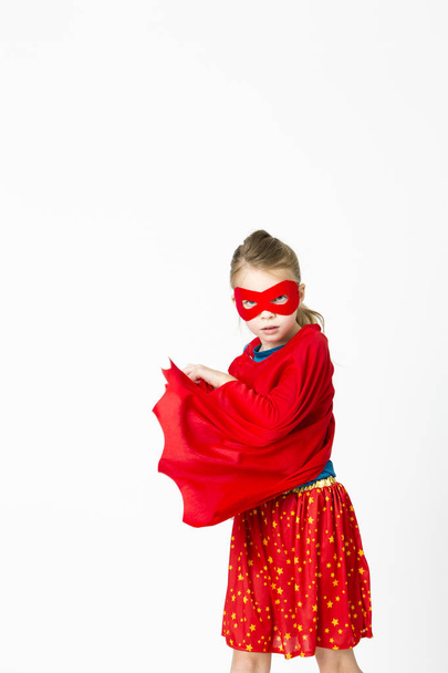 pretty blonde super girl in costume with red mask and cape posing isolated on white background, superhero concept - Photo, Image