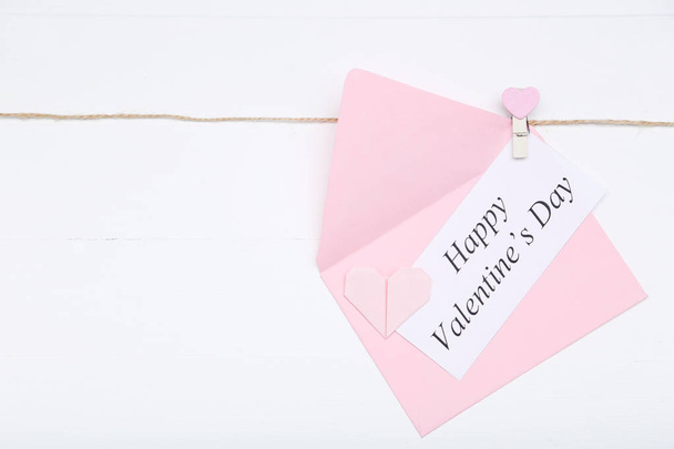 Inscription Happy Valentine Day with envelope and paper heart on white background - Valokuva, kuva