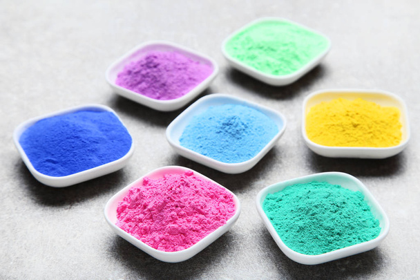 Colorful holi powder in bowls on grey background - Фото, зображення