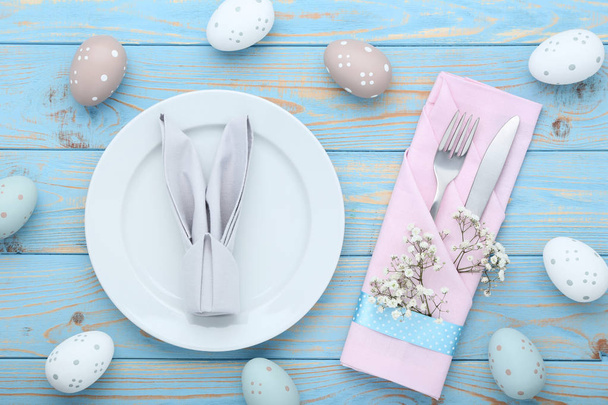 Kitchen cutlery with easter eggs and gypsophila flowers on wooden table - Photo, image
