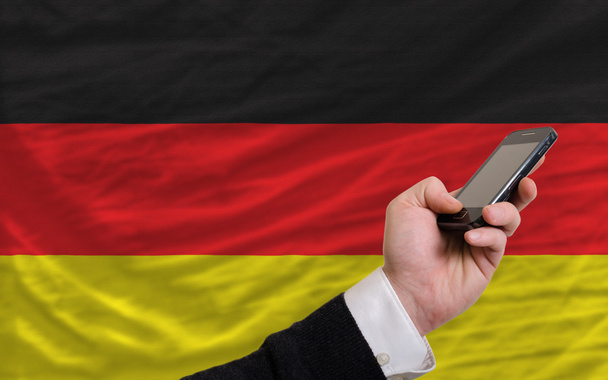 cell phone in front national flag of germany - Fotó, kép