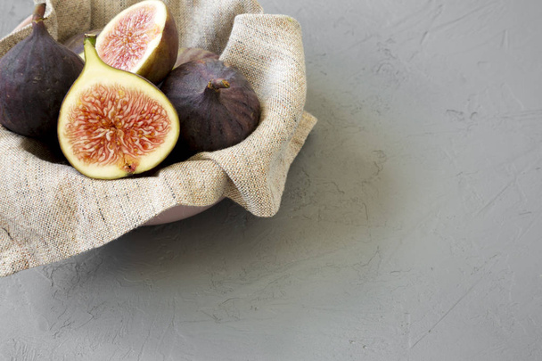 Fresh figs in a bowl over gray background, side view. Space for text. - Photo, Image
