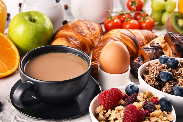 Frühstück mit Kaffee, Orangensaft, Croissants, Ei, Müsli und Obst. Ausgewogene Ernährung. - Foto, Bild