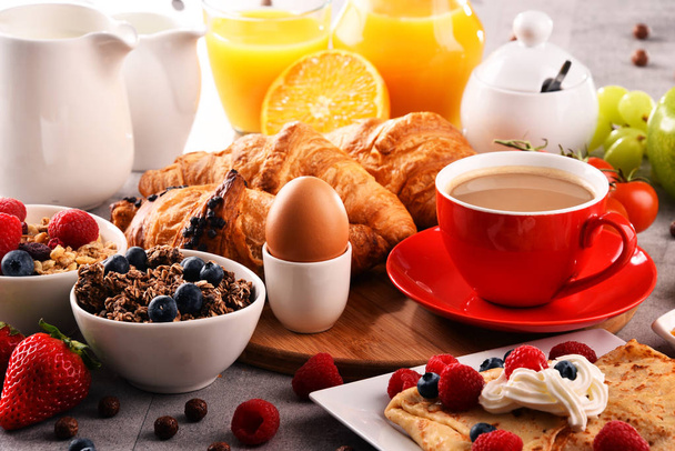 Desayuno servido con café, zumo de naranja, croissants, huevo, cereales y frutas. Dieta equilibrada. - Foto, Imagen