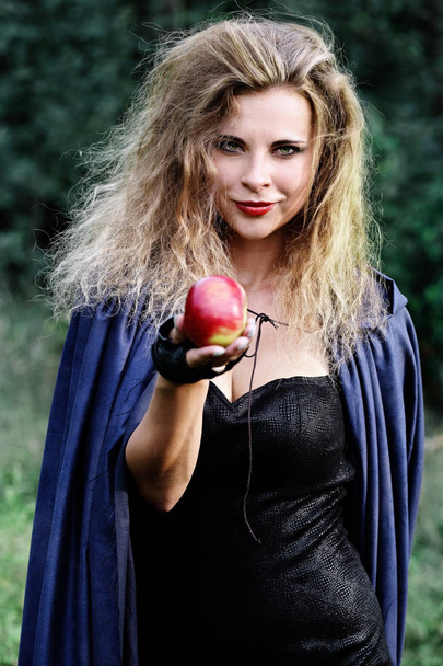 Joven hermosa mujer extiende su mano con una manzana
 - Foto, imagen