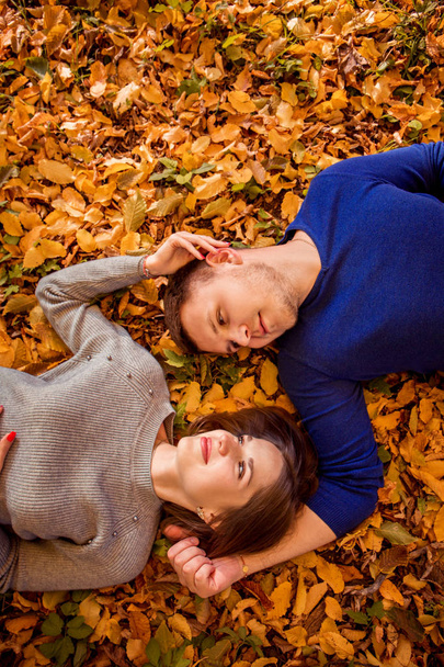 junge Mann und Frau liegen auf dem Herbstlaub - Foto, Bild