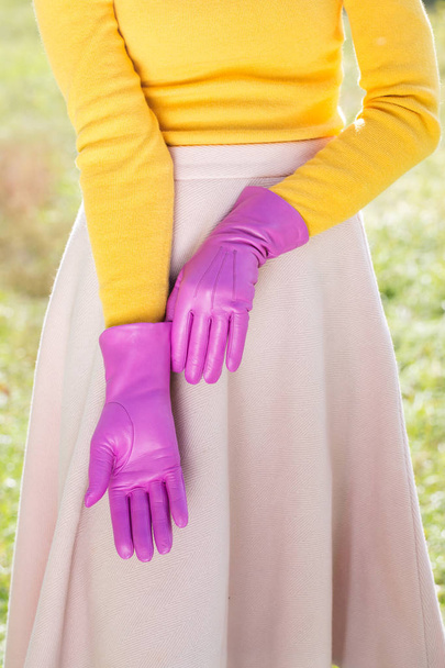 Frau in knallgelbem Pullover und rosa Handschuhen - Foto, Bild