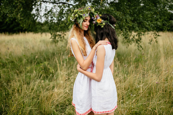 young beautiful women in ethnic clothes in summer field - Foto, imagen