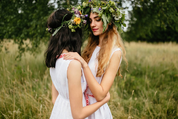 young beautiful women in ethnic clothes in summer field - Foto, Imagen