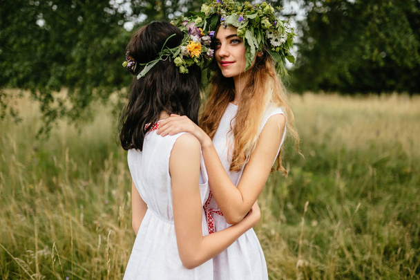 young beautiful women in ethnic clothes in summer field - Fotografie, Obrázek