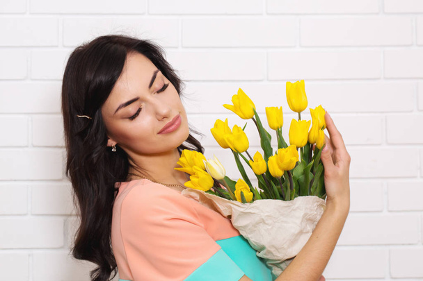 Young beautiful woman with a big bouquet of tulips - Photo, Image