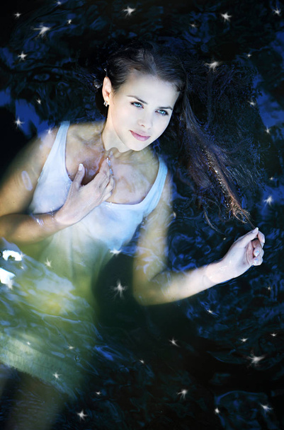Молода красива дівчина в темній річковій воді, вид зверху
 - Фото, зображення
