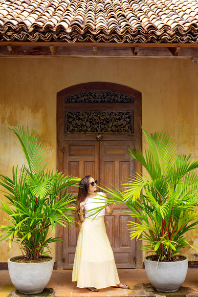 Женщина возле двери с пальмами в вазах
 - Фото, изображение