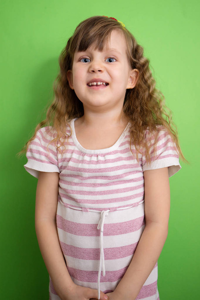 Curly haired girl on a green background - Фото, изображение