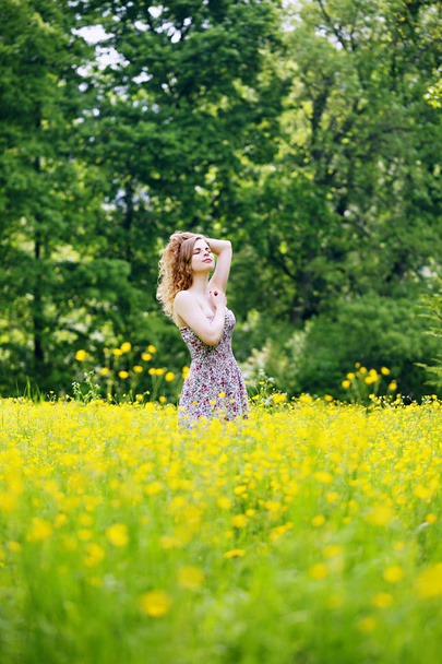 Woman walks through a field of buttercups - Fotoğraf, Görsel