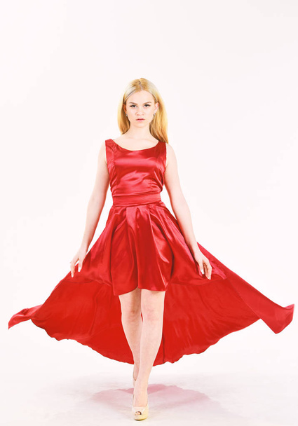 Dress rent service, fashion industry. Woman wears elegant evening red dress, white background. Girl blonde posing in dress. Lady rented fashionable dress for visiting event. Dress rent concept. - Photo, image