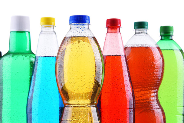 Plastikflaschen mit verschiedenen kohlensäurehaltigen Limonaden in verschiedenen Farben. - Foto, Bild