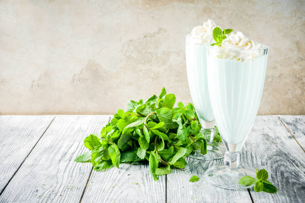 Summer refreshing cocktail, shamrock mint shake, sweet milk drink with fresh mint leaves, wooden background copy space - Photo, Image