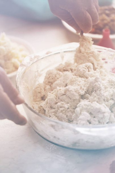 male hand knead the dough into dumplings, close up. photo toning Pastel - Foto, immagini