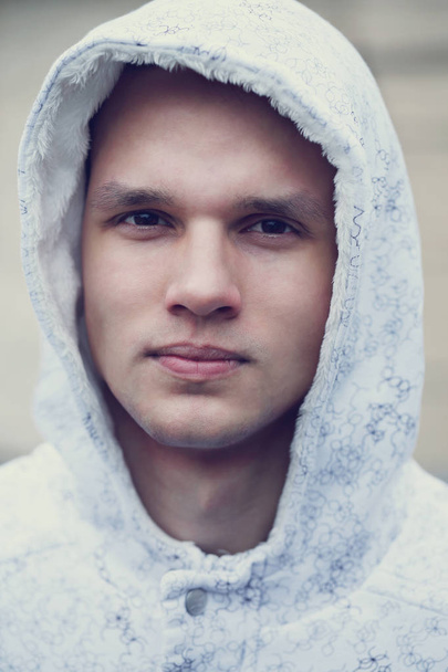 Egy jóképű fiatal férfi fehér kapucnis - Fotó, kép