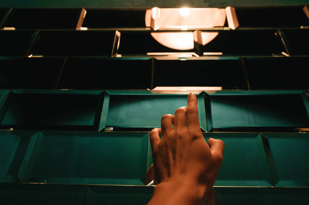 weibliche Hand berührt stilisierte Designer-Ziegel-Glaswand - Foto, Bild