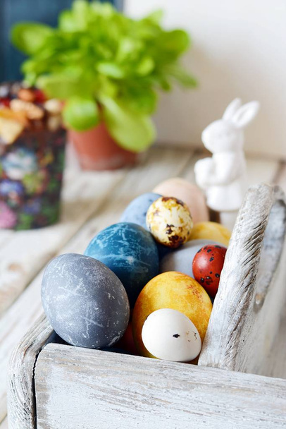 Colored Easter eggs in a wooden basket on a white background. Happy easter. Easter decoration. - Фото, зображення