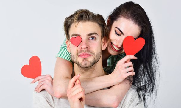 Valentines day and love. Man and woman couple in love hug and hold red heart valentines cards close up. Valentines day concept. Romantic ideas celebrate valentines day. Man and pretty girl in love - Zdjęcie, obraz