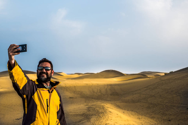 Happy traveler taking selfie with smartphone at desert  - Photo, Image