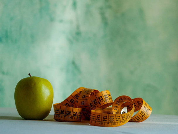 Pojem obezita. Zelené jablko a Svinovací metr nad tabulku - Fotografie, Obrázek