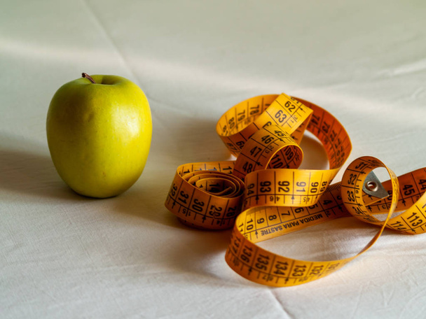 Pojem obezita. Zelené jablko a Svinovací metr nad tabulku - Fotografie, Obrázek