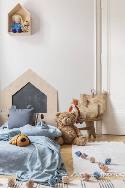 Real photo of a cozy child bedroom interior with a bed, toys and lamps chain on a floor - Foto, Imagen