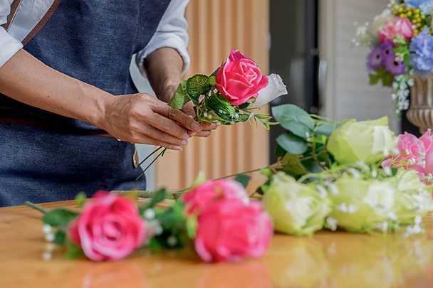 Woman hands making flower composition at florist workshop. Do it yourself concept - Zdjęcie, obraz