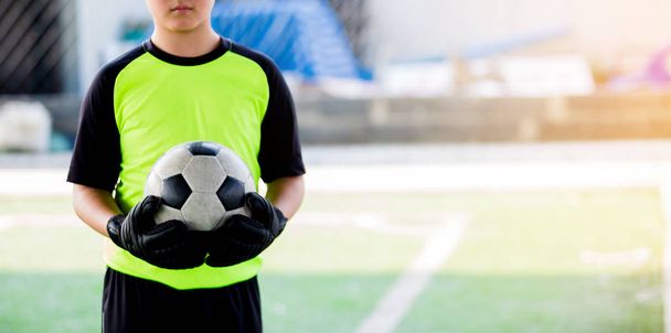 soccer ball in hands of goalkeeper.  Soccer player training or football match. - Fotó, kép