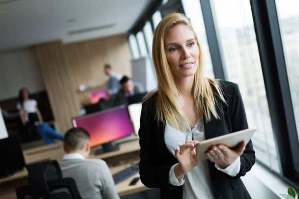Attractive businesswoman using digital tablet in modern office - Foto, Imagem