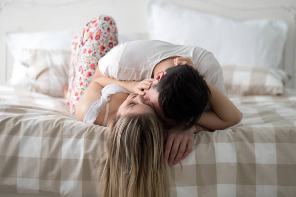 Portrait of young attractive loving couple in bedroom - Foto, Imagem