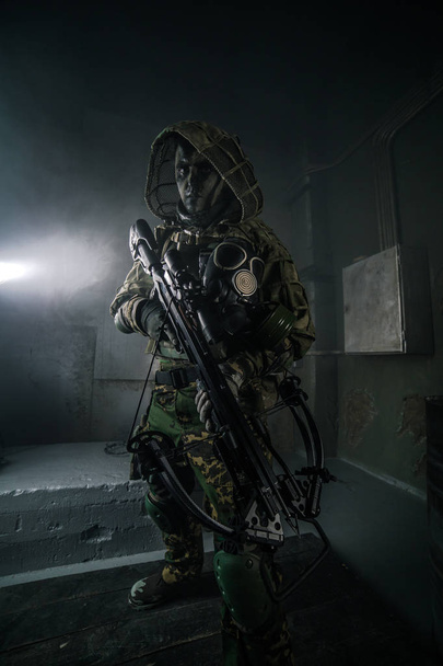 hunter man in camouflage with crossbow posing against dark background - Foto, imagen