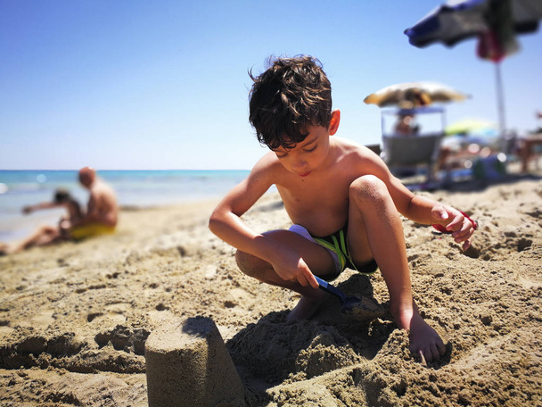 Young boy playing on the beach in Salento - Photo, Image