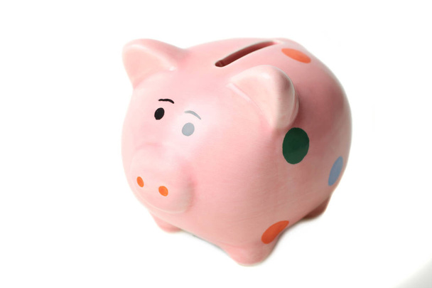 Een roze varken piggy bank in polka dot geïsoleerd op wit. Begrip besparingen. - Foto, afbeelding