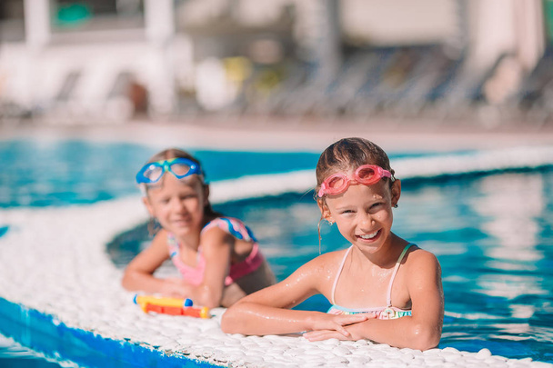 Adorable little girls in outdoor swimming pool - Foto, Bild