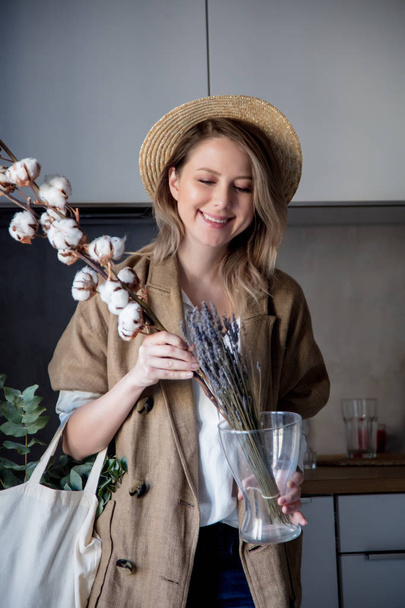 Piękna dziewczyna w marynarka z bawełny roślin w kuchni w domu i torba. Zdrowy i ekologia koncepcja stylu życia - Zdjęcie, obraz
