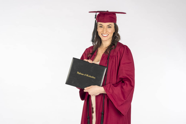 Una splendida modella bruna posa con un diploma dopo la laurea su uno sfondo bianco
 - Foto, immagini