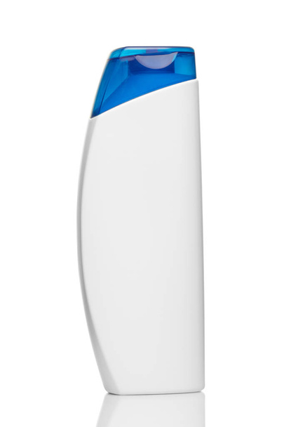 Close-up van witte shampoo fles met blauwe dop op witte achtergrond - Foto, afbeelding