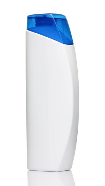 Láhev bílá šampon s modrým víčkem na bílém pozadí zblízka - Fotografie, Obrázek