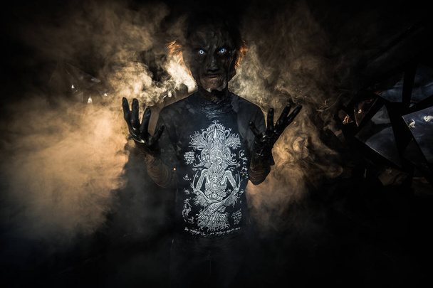 portrait of man in demon mask, posing against background with broken glass - Foto, Imagem