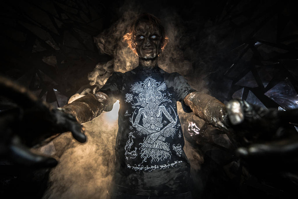 portrait of man in demon mask, posing against background with broken glass - Foto, Bild