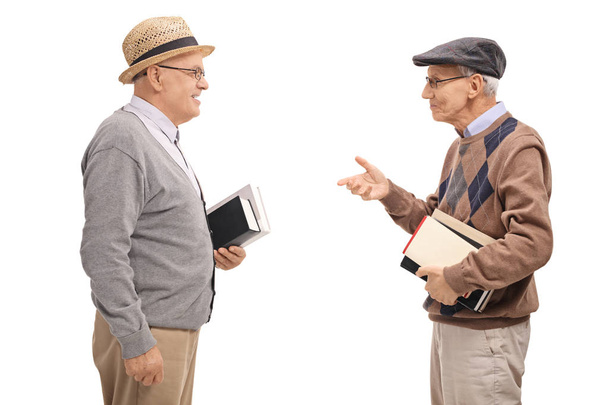 Two senior men holding books and talking isolated on white background - Φωτογραφία, εικόνα