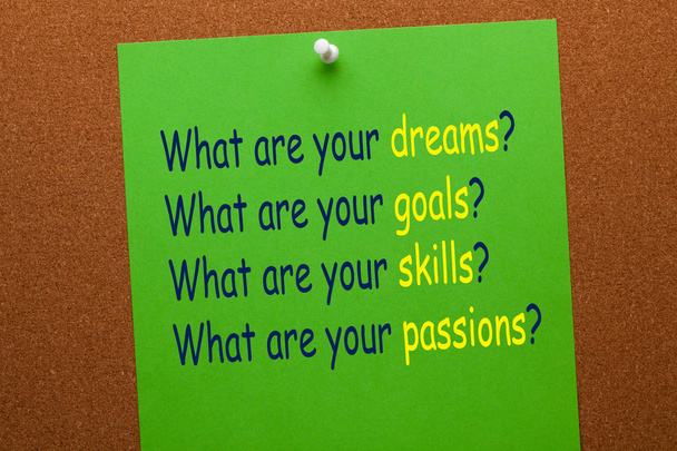 What are your dreams, goals, skills, and passions question on green paper sheet pinned on cork board. Business concept - Photo, Image